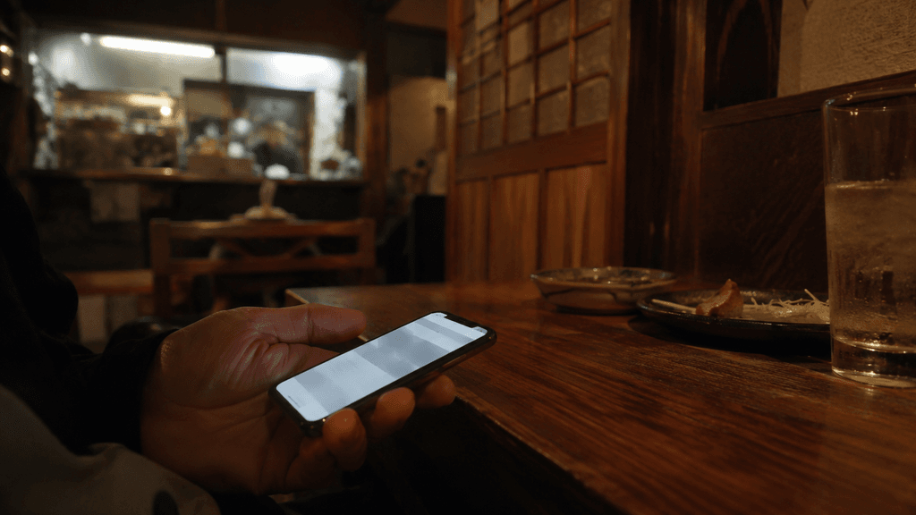 居酒屋でこっそりWEBブラウザを使うイメージ